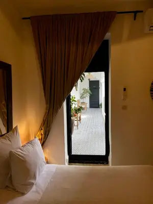 a bedroom with a bed and a window with a patio at Riad Fabiola Et Spa By La Siredrah in Marrakech