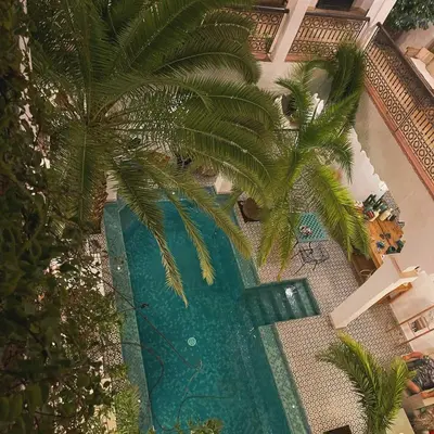 an overhead view of a swimming pool with palm trees at Riad Fabiola Et Spa By La Siredrah in Marrakech
