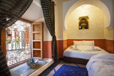 a room with two beds and a window at Riad Zanzibar in Marrakech