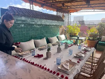 a woman standing in front of a table with roses on it at Riad Dar Al Assad in Marrakech