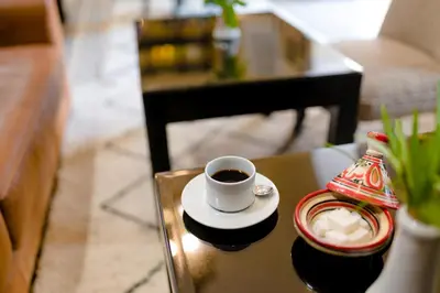 a cup of coffee sitting on top of a table at Riad Amina in Marrakech