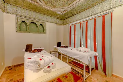 two beds in a room with a ceiling at Riad Amina in Marrakech