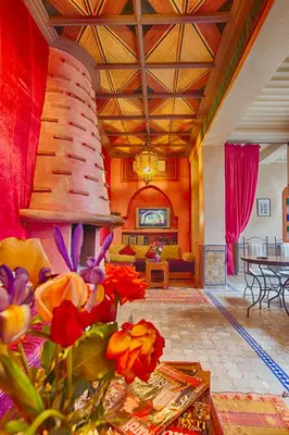 a living room with a couch and a table with flowers at Riad Kenzo in Marrakech