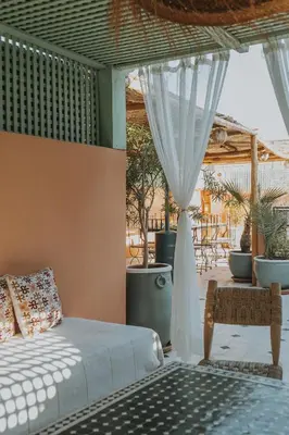 a bedroom with a bed and a patio with plants at Riad Dar Coram in Marrakech