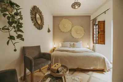 a bedroom with a bed and a chair and mirrors at Riad Dar Coram in Marrakech
