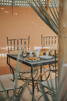 a table with food on it with two chairs at Riad Dar Coram in Marrakech