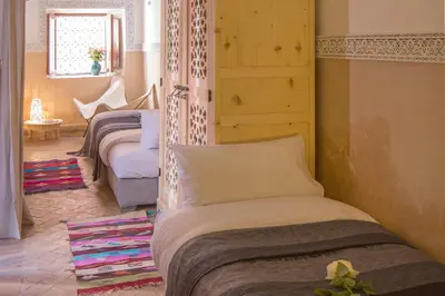 a bedroom with three beds in a room at Riad Assala in Marrakech