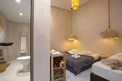 a bathroom with a bed and a toilet and a sink at Riad El Kennaria in Marrakech