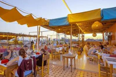 a group of people sitting at tables in a restaurant at Riad El Kennaria in Marrakech