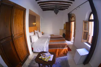 a bedroom with a bed and a table and a door at Riad Hidden in Marrakech