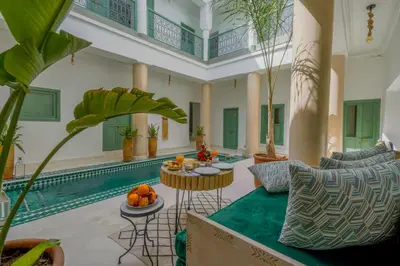 a living room with a pool and a table with fruit on it at Riad Trésor in Marrakech