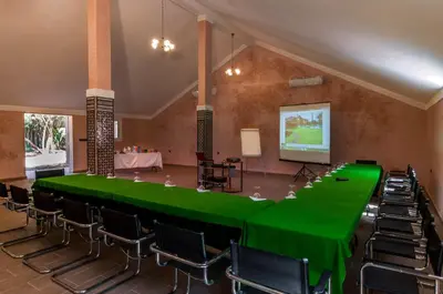a conference room with a green table and chairs at Villa Des 3 Golfs in Marrakech