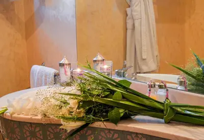 a bathroom sink with a bouquet of flowers and candles at Villa Des 3 Golfs in Marrakech