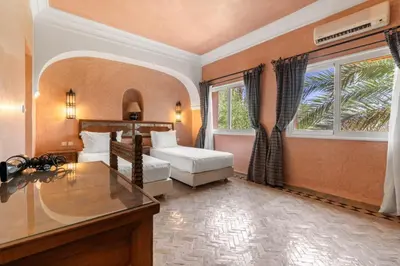 a bedroom with a bed and a desk and a window at Villa Des 3 Golfs in Marrakech