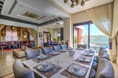 a dining room with a long table and chairs at Villa Nelya in Marrakech
