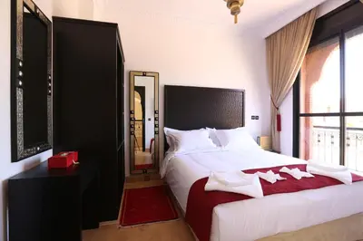 a bedroom with a large white bed and a mirror at Villa Nelya in Marrakech