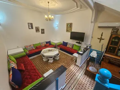 a living room with a couch and a tv at Riad Noureddine in Marrakech