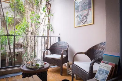 a porch with two chairs and a table and a balcony at Riad Adrar in Marrakech