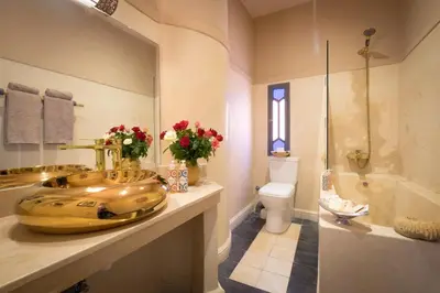 a bathroom with a gold sink and a toilet at Riad Adrar in Marrakech