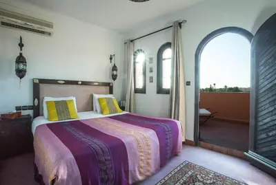 a bedroom with a large bed and a balcony at Villa Amira & Spa in Marrakech