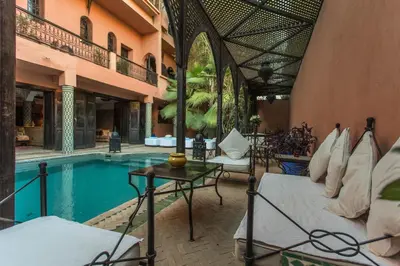 a resort with a pool and a bed and a table at Villa Amira & Spa in Marrakech