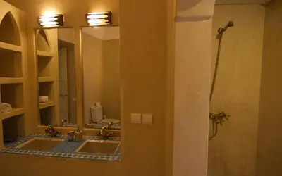 a bathroom with two sinks and two mirrors at Dar Crystal in Marrakech