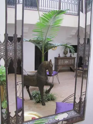 a mirror with a statue of a dog in a room at Riad Houdou in Marrakech