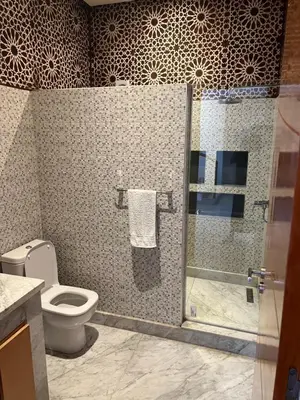 a bathroom with a toilet and a glass shower stall at Villa DAAB OURIDA piscine chauffée Salle de sport in Marrakech