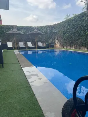 a large swimming pool with chairs and umbrellas at Villa DAAB OURIDA piscine chauffée Salle de sport in Marrakech