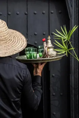 a person holding a tray with drinks on it at Riad Danka in Marrakech