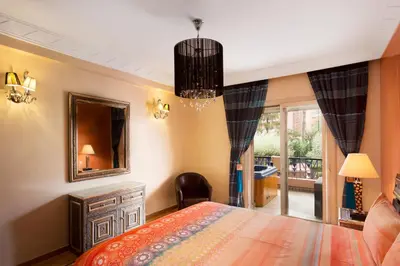 a bedroom with a bed and a mirror and a chair at The Sapphire Apartment with Private Swimming Pool & Hot Tub - Hivernage Quarter - By Goldex Marrakech in Marrakech