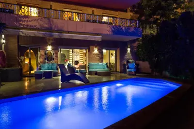 a swimming pool in front of a house at night at The Sapphire Apartment with Private Swimming Pool & Hot Tub - Hivernage Quarter - By Goldex Marrakech in Marrakech