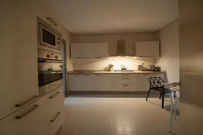 a kitchen with white appliances and a table and a chair at Villa Loubane in Marrakech