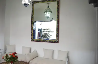 a living room with a white couch and a mirror at Riad Wink in Marrakech