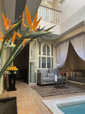 a living room with a couch and a swimming pool at Riad Cocoon in Marrakech