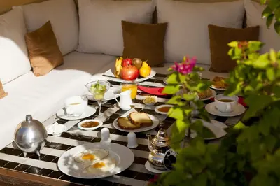 a breakfast table with eggs and fruit on a couch at Riad Cocoon in Marrakech