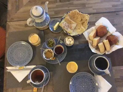 a table topped with cups of coffee and plates of food at Riad Tchina in Marrakech