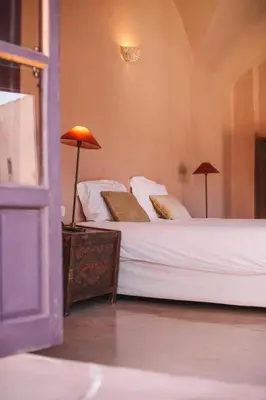 a bedroom with two beds and two lamps on a table at Caravan Serai in Douar Khalifa Ben Mbarek