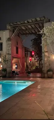 a swimming pool in front of a building at night at Caravan Serai in Douar Khalifa Ben Mbarek