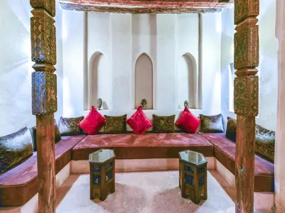 a room with a bench with red pillows on it at Caravan Serai in Douar Khalifa Ben Mbarek