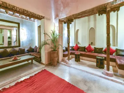 a living room with couches and a red rug at Caravan Serai in Douar Khalifa Ben Mbarek