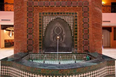 a bath tub in a brick wall with a fountain at Mogador Menzah Appart Hôtel in Marrakech