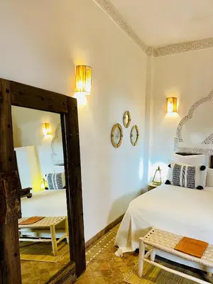 a bedroom with two beds and a mirror at Riad La Porte Rouge By La Siredrah in Marrakech