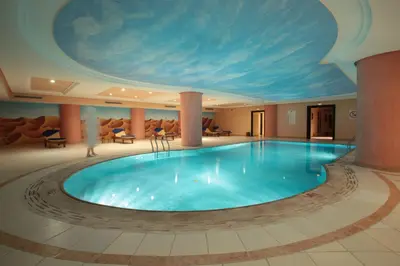 a large swimming pool with a painting on the ceiling at Grand Mogador Menara & Spa in Marrakech