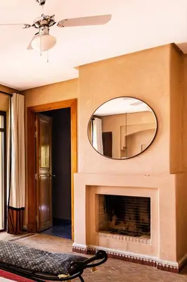 a living room with a fireplace and a mirror at Villa de Luxe avec Piscine Privée et Golf in Marrakech