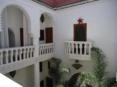 a white room with a staircase and a mirror at Riad Tahar Oasis in Marrakech