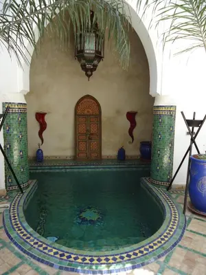 a swimming pool in a building with a house at Riad Tahar Oasis in Marrakech