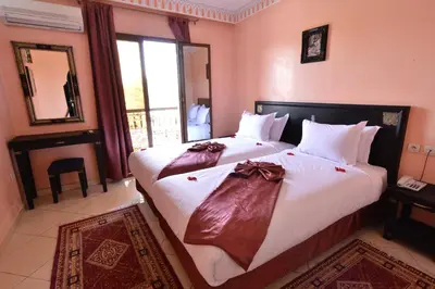 a bedroom with a large bed with two robes on it at Hotel El Hadna By HMS in Marrakech