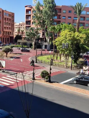 a street in a city with a road with cars at Hotel El Hadna By HMS in Marrakech