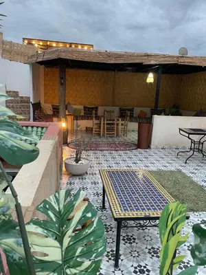 an outdoor patio with a table and chairs and a patio with at Hotel Riad Fantasia in Marrakech